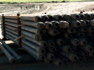 Racked used drill pipe with thick tool-joint ends at a North Dakota well site